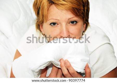 happy caucasian woman in white clean bedding portrait