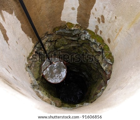 pulling out bucket full of drink water from deep well