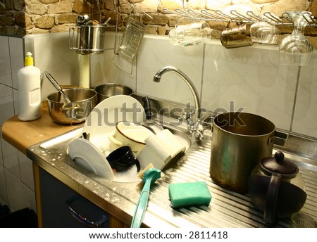 Lots of dirty dishes in small kitchen\'s sink