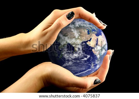 View at east side of earth held by woman\'s hands on a black background. Image of earth used under Terms and Condintions of Nasa http://visibleearth.nasa.gov