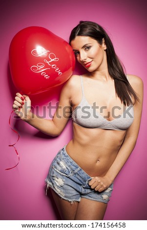 Sexy woman with valentines day balloon on pink background