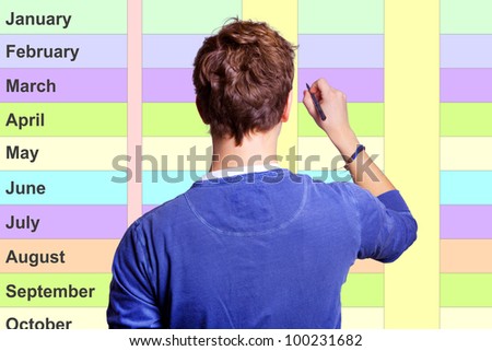 Young man stands on the year planner