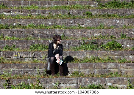 Woman sits alone on stone steps