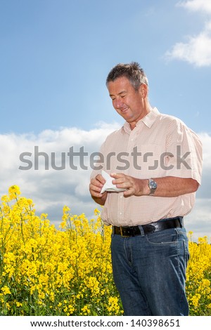 Man with hay fever on blooming rapeseed field