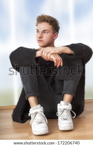 Casual dressed man sitting on the floor