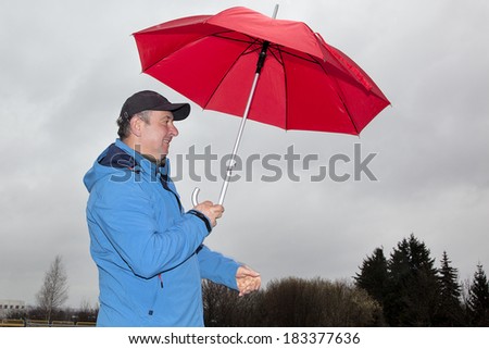 Man running with umbrella in rainy stormy weather