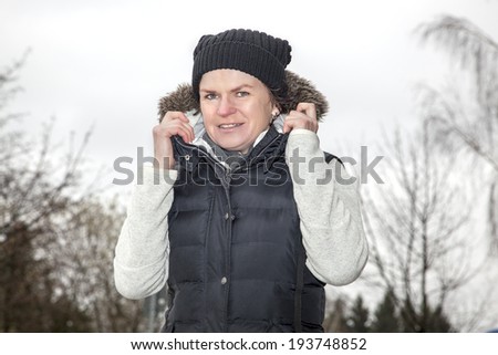 Woman with wool hat walks across the parking