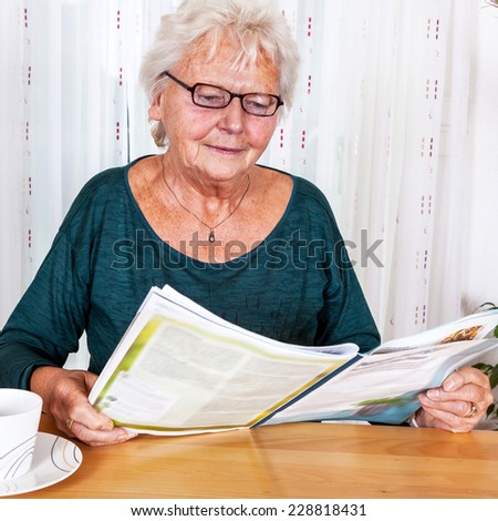 Elderly woman reading a magazine