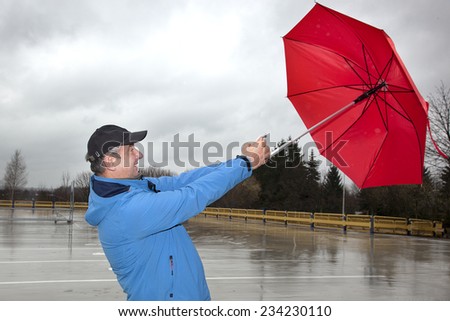 Man running with umbrella in rainy stormy weather
