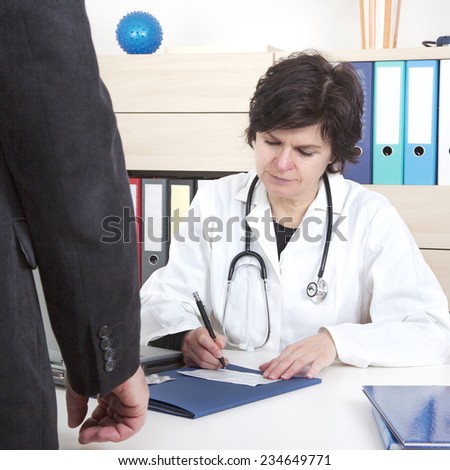 Doctor writes prescription for patients