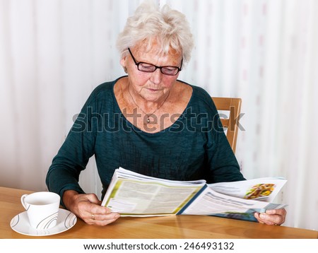 Elderly woman reading a magazine
