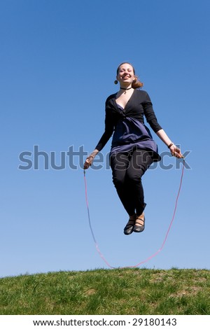 girl with skipping rope on a green meadow