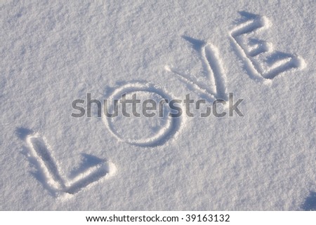 writing text LOVE on the snow