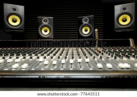 Low angle shot of a mixing desk with yellow and black speakers