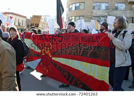 MADISON, WI - FEB 19: Unidentified people protest WI Budget Repair Bill on February 19, 2011 on the capitol square in Madison, Wisconsin.  The protesters hold a banner demonstrating solidarity.