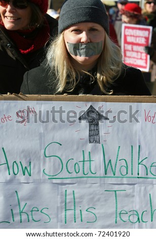 MADISON, WI - FEB 19: Unidentified woman protests WI Budget Repair Bill on February 19, 2011 on the capitol square in Madison, WI.  The woman wears tape on her mouth representing having no voice.