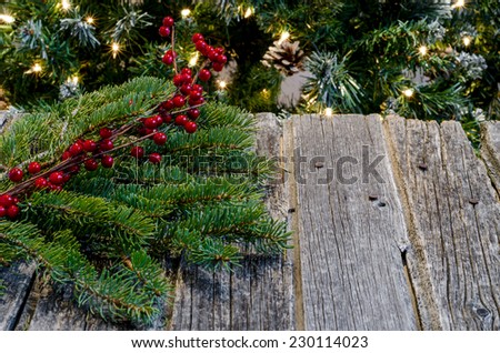 Christmas decorations on rustic wood with tree in background & text space