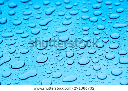 Background image using cooling blue color with raindrops on a window