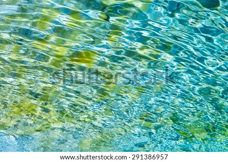 Sparkling colorful water creating patterns on sand bottom