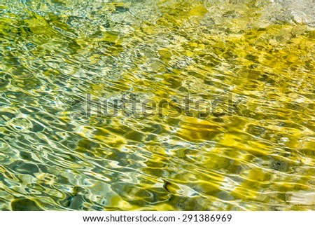 Sparkling colorful water creating patterns on sand bottom