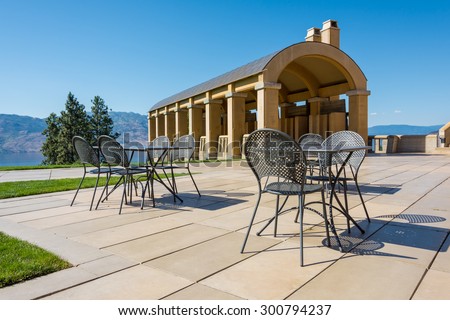 Empty patio table & chairs at a winery inspired by old Tuscany style architecture