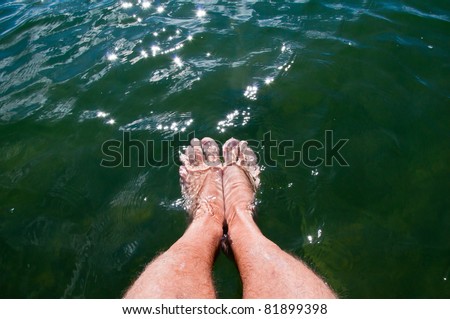 Dipping feet in water off a dock on a hot summer day