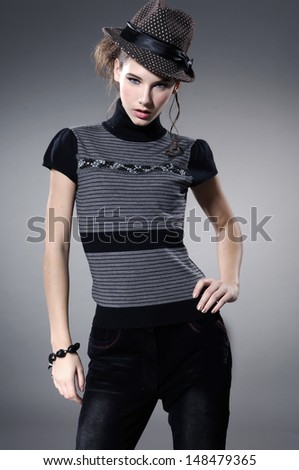 fashion model in modern clothes posing on gray background