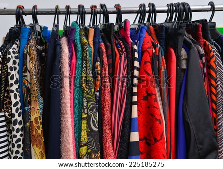 Variety of colorful fashion clothing on hanging-gray background