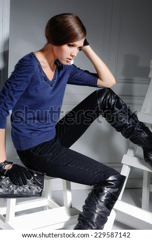 High fashion model sitting cube posing wooden ladder in the studio
