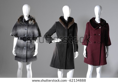 Gray background -three dummies dressed fur coat a winter in suits