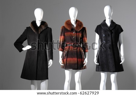 Set of Three dummies dressed in coat on gray background