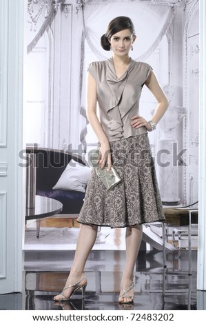 fashion girl holding little purse posing in the studio