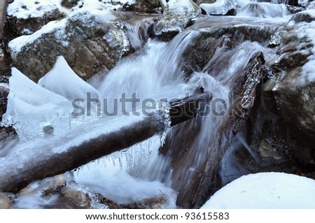 Cascade in winter with frozen log, frozen waterfall, Frozen fall,