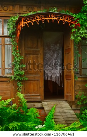 Steps of the old wooden house decorated with ivy. vine runs over the porch.