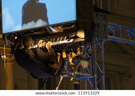 BUCHAREST, ROMANIA - SEPTEMBER 13: David Moreno plays his floating piano during B-FIT in the Street International Street Theater Festival on September 13, 2012 in Bucharest, Romania.
