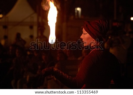 BUCHAREST, ROMANIA - SEPTEMBER 13: Lara Castiglioni plays with fire torch during B-FIT in the Street, International Street Theater Festival on September 13,  2012 in Bucharest, Romania.