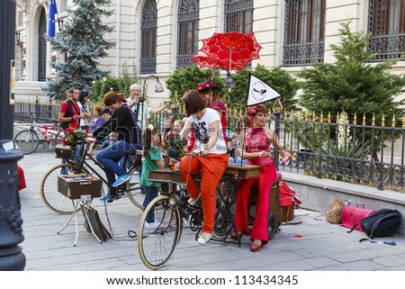 BUCHAREST, ROMANIA - SEPTEMBER 13: Unidentified lady cycles the stationary bike to power the sewing machine during B-FIT in the Street Festival on  September 13, 2012 in Bucharest, Romania.