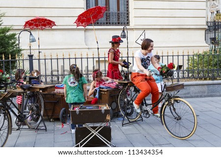 BUCHAREST, ROMANIA - SEPTEMBER 13: Unidentified lady cycles the bike to power the sewing machine and old record player during B-FIT in the Street  Festival on September 13, 2012 in Bucharest, Romania.