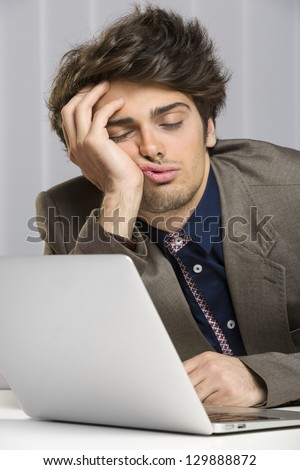 Portrait Of Sleeping Overworked Businessman In Front Of His Laptop At Work.