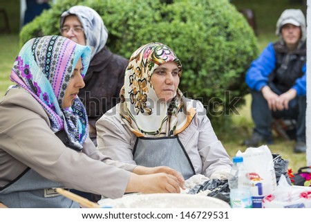 BUCHAREST, ROMANIA - MAY 17: Turkish cook women knead dough for traditional suberek pie during the celebratory event Turkish Festival on May 17, 2013 in Bucharest, Romania.