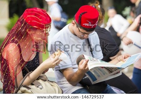 BUCHAREST, ROMANIA - MAY 17: Unidentified young Turkish people gather, relax and socialize in the park during the celebratory event Turkish Festival on May 17, 2013 in Bucharest, Romania.