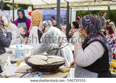 BUCHAREST, ROMANIA - MAY 17: Turkish woman cook bakes traditional suberek pie during the celebratory event Turkish Festival on May 17, 2013 in Bucharest, Romania.