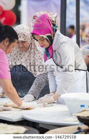 BUCHAREST, ROMANIA - MAY 17: Turkish women knead the dough for traditional suberek pie during the celebratory event Turkish Festival on May 17, 2013 in Bucharest, Romania.