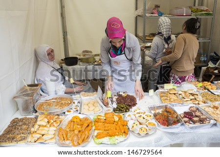 BUCHAREST, ROMANIA - MAY 17: Turkish women sell traditional pies, cakes and sweets at stand during the Turkish Festival on May 17, 2013 in Bucharest, Romania.