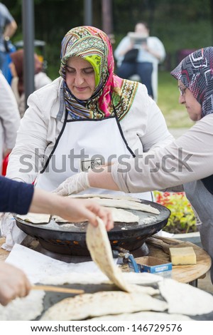 BUCHAREST, ROMANIA - MAY 17: Turkish women bake traditional suberek pie during the celebratory event Turkish Festival on May 17, 2013 in Bucharest, Romania.