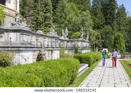 SINAIA, ROMANIA - JULY 24: Unidentified tourists walk the alleys of Peles castle garden on July 24, 2013 in Sinaia, Romania. Every year, more than 300.000 tourists visit the famous Peles castle.