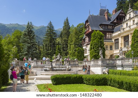 SINAIA, ROMANIA - JULY 24: Unidentified tourists enjoy the view of Peles castle on July 24, 2013 in Sinaia, Romania. Peles castle is visited by more than 300.000 tourists every year.