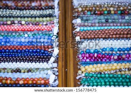 Detail view of many various colorful necklaces, collars, bracelets, beads, accessories and souvenirs.