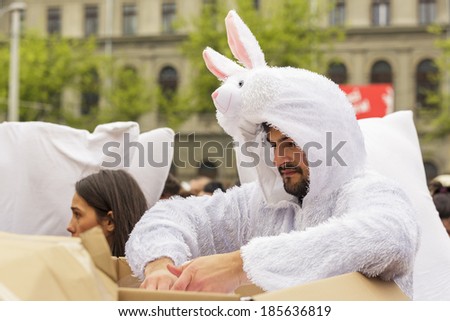 BUCHAREST, ROMANIA - APRIL 5: Unidentified man in white bunny costume give white pillows to the crowd on International Pillow Fight Day on April 5, 2014 in University Square, Bucharest, Romania.