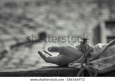 Closeup of hand nailed on wooden cross as a reenactment of the crucifixion of Jesus Christ.